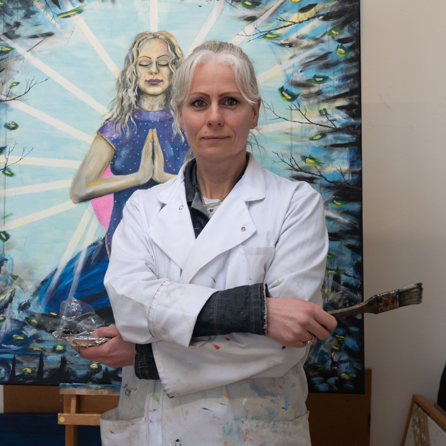 Renate Engelen in haar atelier, voor een schilderij van een mediterende vrouw